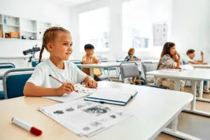 Meisje oefent schrijven in een klaslokaal